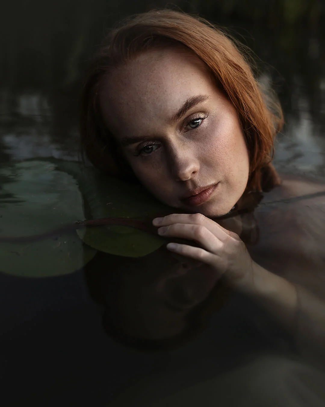 Porträttfotografering - vattenporträtt, en kvinna (Natali Skoglund) med rött hår i vattnet. Portrait photography - water portrait, a woman (Natali Skoglund) with red hair in the water.