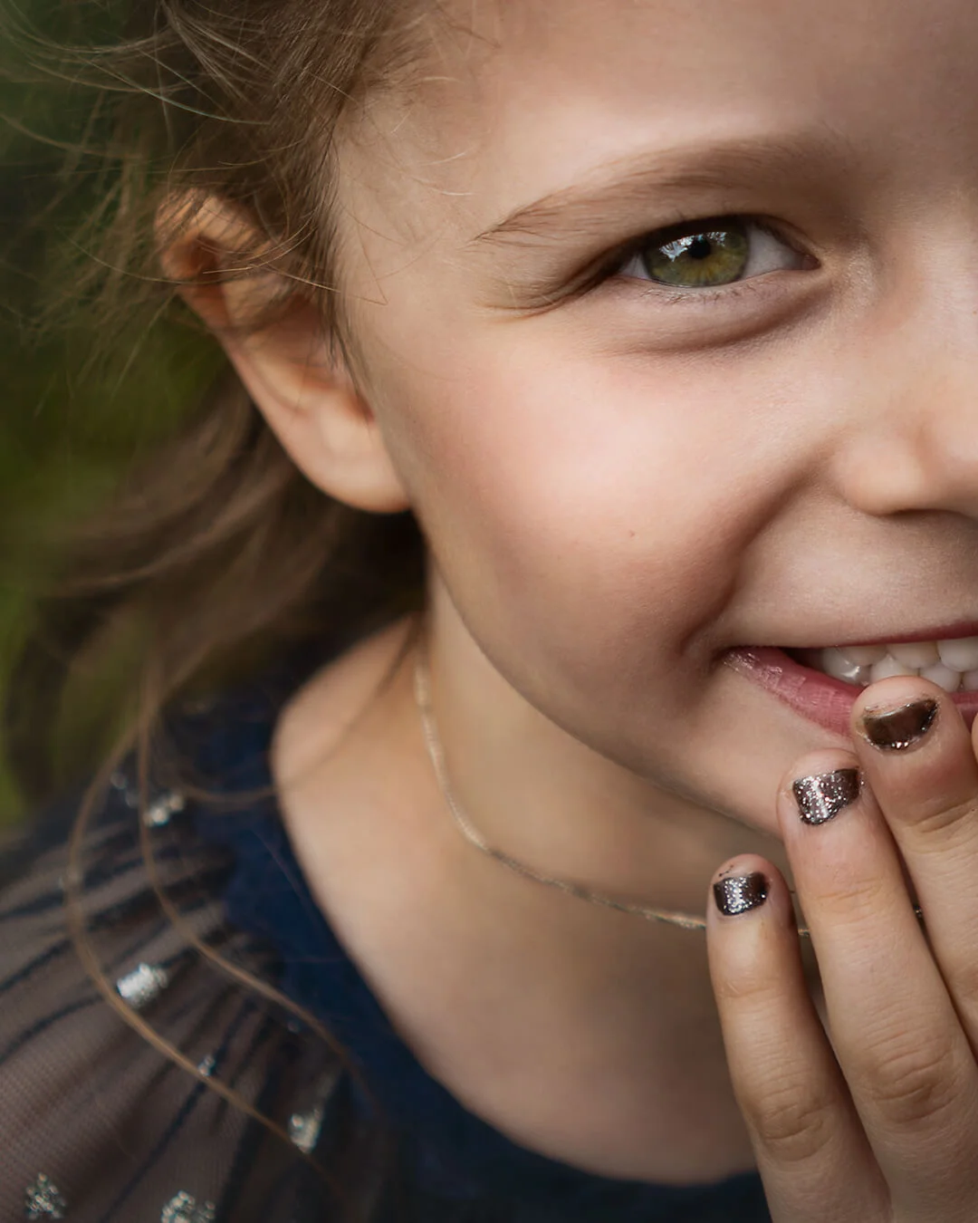 Barnfotografering - nära porträtt på en glad flicka med gröna ögon. Child photography - close up portrait of a happy girl with green eyes.