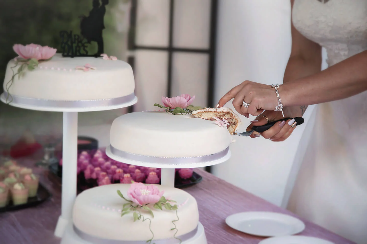 Bröllopsfotografering - brudparet skär tårtan. Wedding photography - the bride and groom cutting the cake.