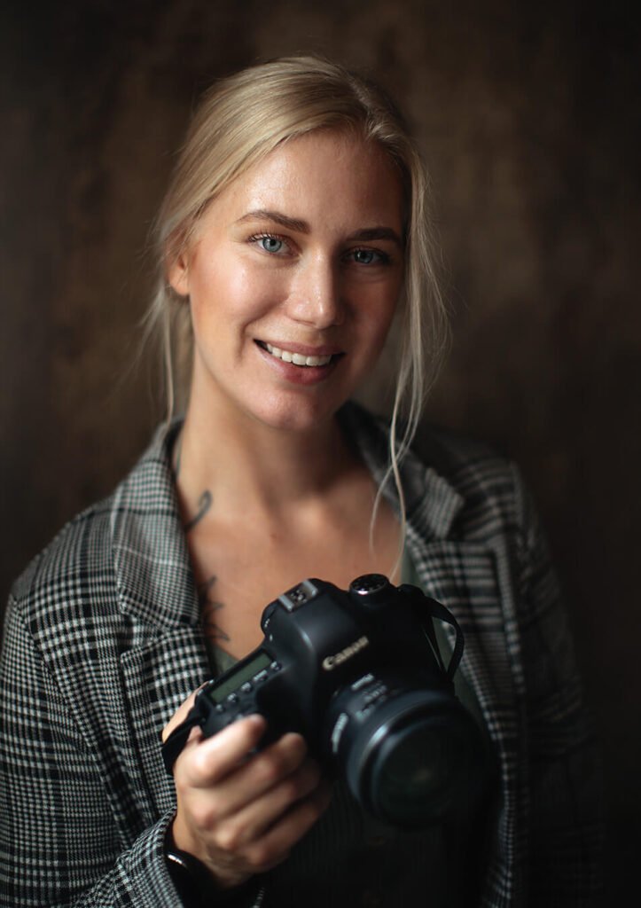 Porträttfotografering - företagsfoto, företagsporträtt. Porträtt på en kvinnlig fotograf som håller i en Canon kamera. Företagsfoto Västerås. Företagsfotografering Västerås. Portrait photography - corporate photo, corporate portrait. Portrait of a photographer holding a Canon camera.